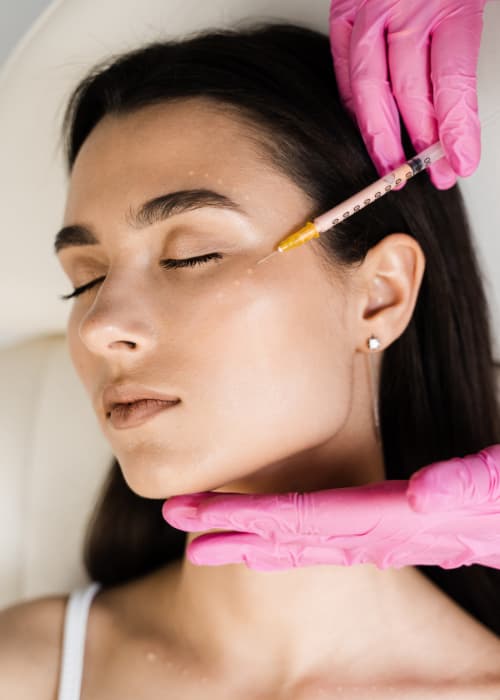 Woman Getting cheek treatment with a needle - injection